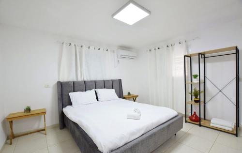 um quarto com uma cama grande e lençóis brancos em וילה ויליז'ן em H̱azon