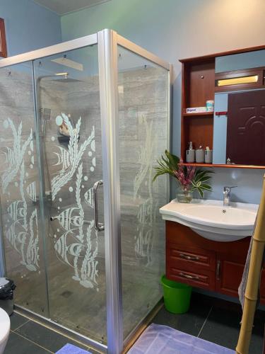 La salle de bains est pourvue d'une douche et d'un lavabo. dans l'établissement Tiki House, à Bora Bora