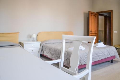 sypialnia z 2 łóżkami i białym krzesłem w obiekcie Hotel Domus w mieście Maranello