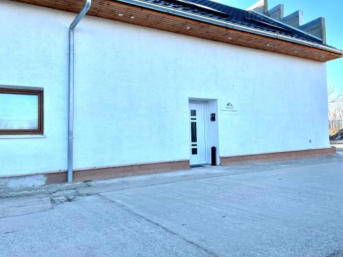 un bâtiment blanc avec une porte sur son côté dans l'établissement #WORLD Monteur Apartment, à Schkeuditz