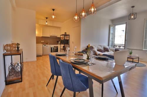 une salle à manger et un salon avec une table et des chaises dans l'établissement Appartement hypercentre troyes, à Troyes