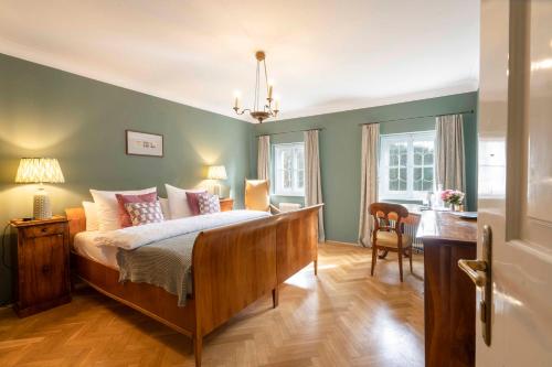 um quarto com uma cama e uma secretária. em Der Schlosswirt zu Anif - Biedermeierhotel und Restaurant em Anif