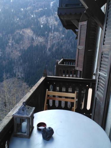 a table on a balcony with a view of the mountains at À Flanc de Montagne in Le Trétien