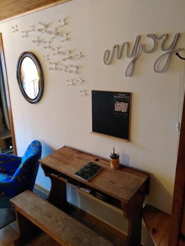 a room with a table and a sign on the wall at À Flanc de Montagne in Le Trétien