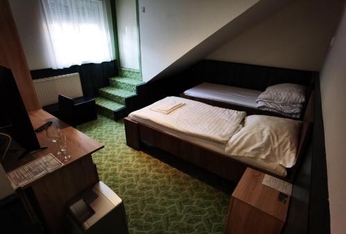 małe łóżko w małym pokoju z oknem w obiekcie KOMPLEX -Rendezvénytermek-Panzió-Apartman-Irodák- w mieście Mátészalka
