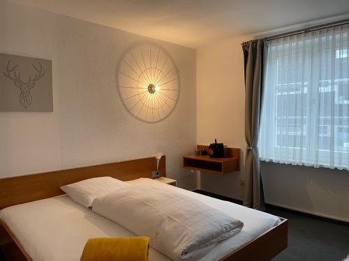 a bedroom with a bed with white sheets and a window at Hotel Jägerhof in Coesfeld