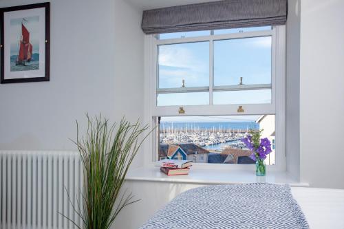 1 dormitorio con ventana y vistas a la ciudad en Golden Vanity, Maritime Suites, Brixham, en Brixham