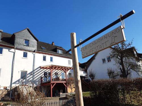 a street sign in front of a white house at Ferienwohnungen Schiffstatt in Guxhagen