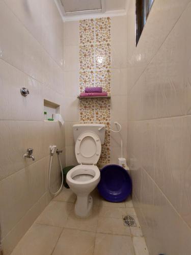 uma pequena casa de banho com WC e chuveiro em Amarossi Rhino-Studio Terrace Apartment,Mtwapa em Mtwapa