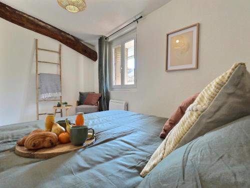 a tray of fruit on a bed in a bedroom at LE LIMOUCHE Proche Centre Parking Gratuit in Chabeuil