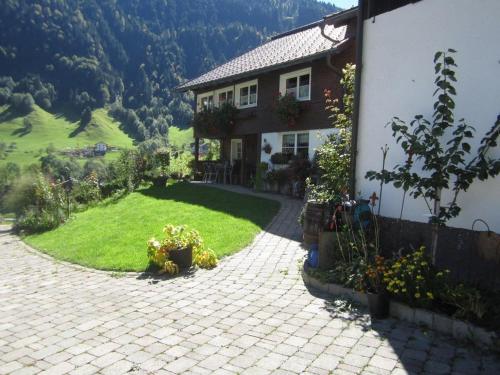 uma casa com um jardim relvado ao lado de um edifício em Ferienwohnung Helma em Blons