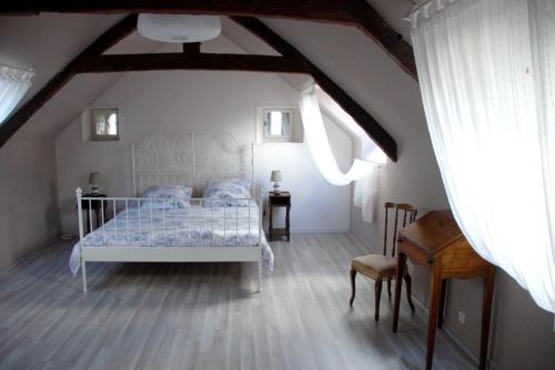 une chambre avec un lit blanc dans un grenier dans l'établissement Maison charmante à Jugon-les-Lacs avec jardin, à Jugon Les Lacs
