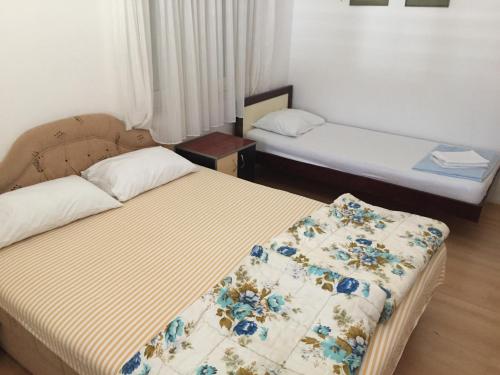 a bedroom with two beds with a blanket on it at Apartments Roza in Herceg-Novi