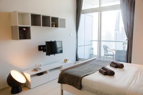 a bedroom with a bed and a tv on a wall at HiGuests - Studio With Incredible Sea Views, 3-min to Beach in Dubai