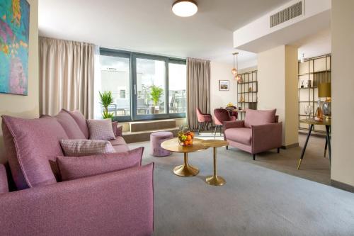 a living room with purple chairs and a table at Xerion Hotel in Kraków