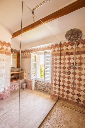 une salle de bain avec une douche avec une porte vitrée dans l'établissement Gîte - Mas de Louise, à Rousson