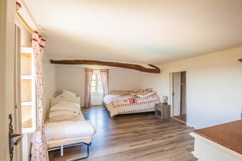 a bedroom with two beds and a wooden floor at Gîte - Mas de Louise in Rousson