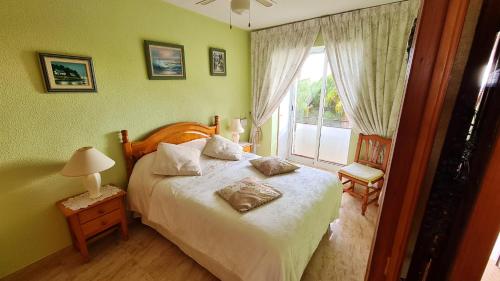 een slaapkamer met een groot bed en een raam bij 2 bedrooms apartement at Mazarron 400 m away from the beach with sea view shared pool and jacuzzi in Mazarrón