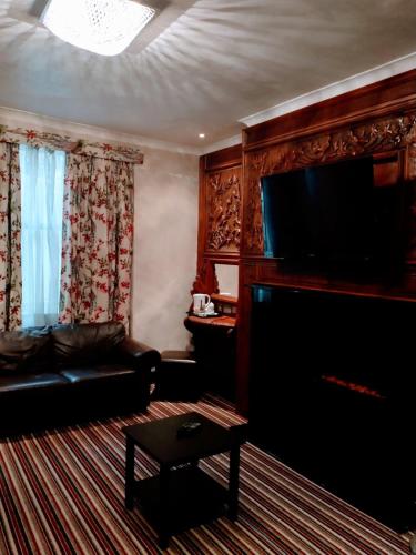 a living room with a couch and a flat screen tv at Hotel Edward Paddington in London