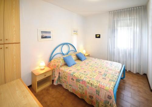- une chambre avec un lit doté d'oreillers bleus et d'une fenêtre dans l'établissement Appartamenti Nasse, à Bibione