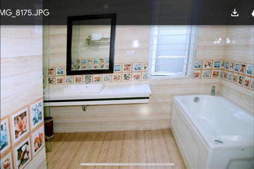 a bathroom with a tub and a sink and a mirror at Victory Hotel, số 7, Vương Thúc Mậu, Tp Vinh in Vinh