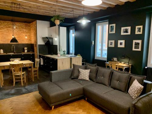 a living room with a couch and a kitchen at The Loft, by So & Dam’s in Thonon-les-Bains