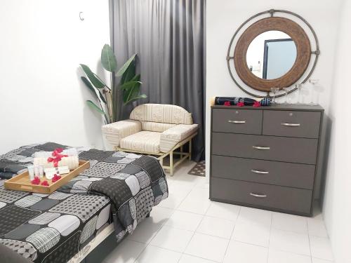 - une chambre avec un lit, une commode et un miroir dans l'établissement Islamic Homestay Apartment Kundang, Rawang, à Rawang