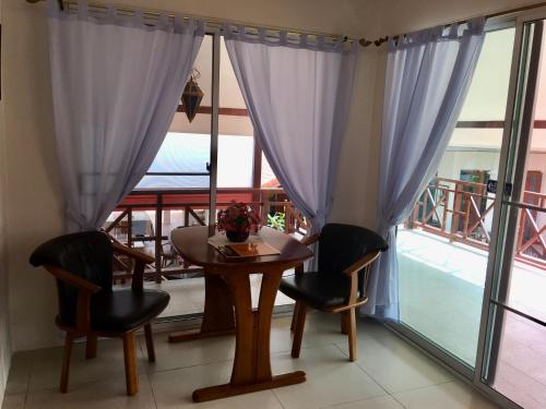 a dining room with a table and chairs and a balcony at Naraya Homestay in San Pa Tong