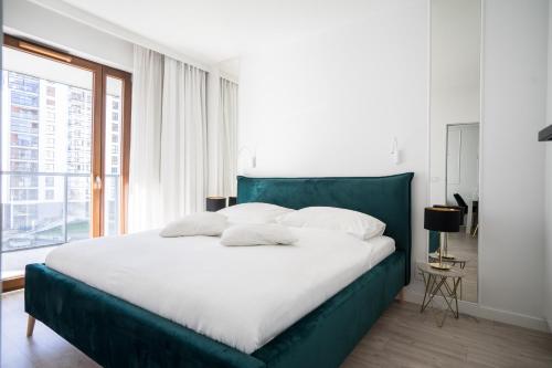 uma cama verde num quarto branco com uma janela em Old Town Heart IX Luxury - Przyokopowa em Varsóvia