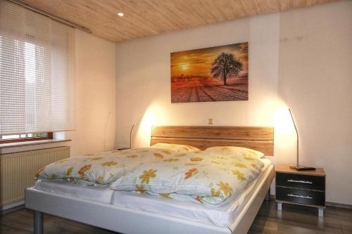 a bedroom with a bed and a painting on the wall at Ferienwohnung am Felsenkeller in Lahrbach