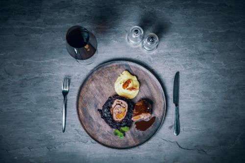 a plate of food on a table with fork and knife at Apparthotel Restaurant Steiners in Eben im Pongau