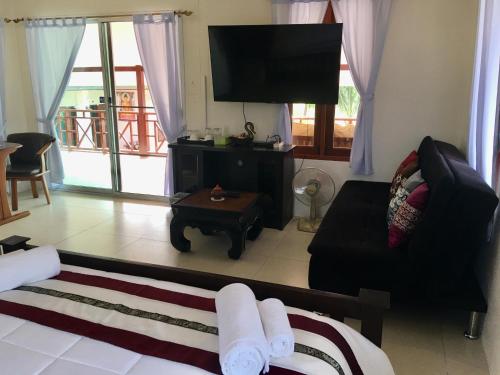 a living room with a couch and a flat screen tv at Naraya Homestay in San Pa Tong