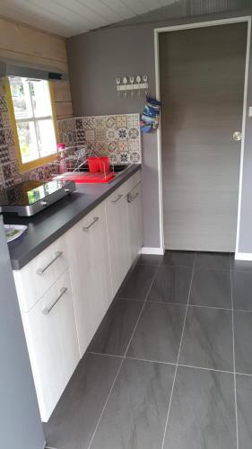 a kitchen with white cabinets and a black counter top at Chalet Cosy in Audenge