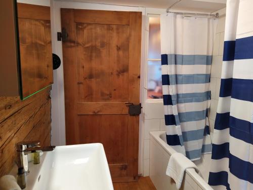 a bathroom with a sink and a wooden door at Apartment Meinradsberg mit Balkon in Einsiedeln
