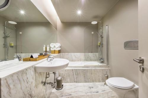 La salle de bains est pourvue d'un lavabo, d'une baignoire et de toilettes. dans l'établissement Villa C Boutique Hotel, à Vila do Conde