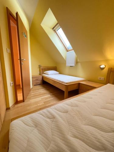 um quarto no sótão com uma cama e uma janela em Apartma Idila em Zrece