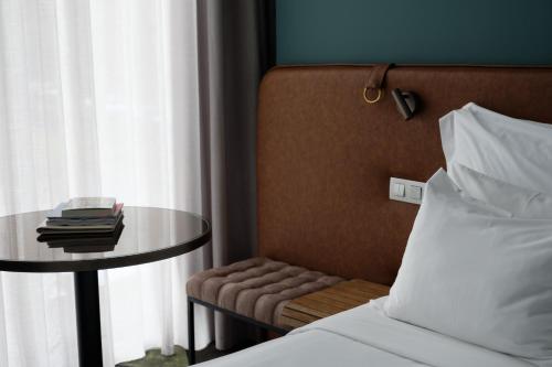 a bedroom with a table and a bed and a table and chair at Octant Furnas in Furnas