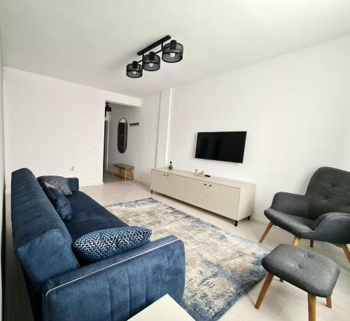 a living room with a blue couch and a tv at Dolphin Apartment near Neversea Beach in Constanţa