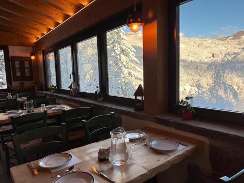 a restaurant with tables and chairs and a view of a mountain at R&B Casa Benassi in Riolunato