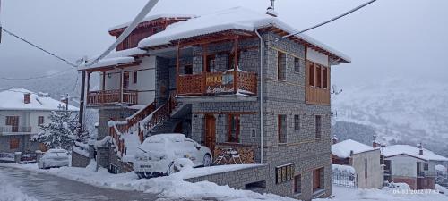 a building covered in snow with a ski lift at La Petri Studios with Fireplace & View in Metsovo