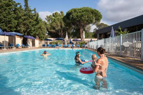 a group of people playing in a swimming pool at Feriendorf zum störrischen Esel in Calvi
