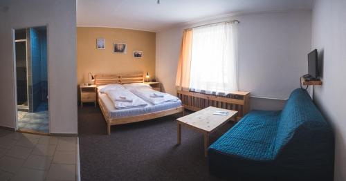 1 dormitorio con cama, sofá y mesa en Penzion Zornicka, en Donovaly
