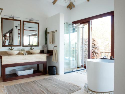 a bathroom with two sinks and a large mirror at Mawemawe Manyara Lodge in Kaiti