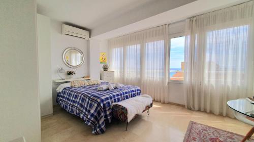 ein Schlafzimmer mit einem Bett und einem großen Fenster in der Unterkunft Estudio Playa del Postiguet in Alicante