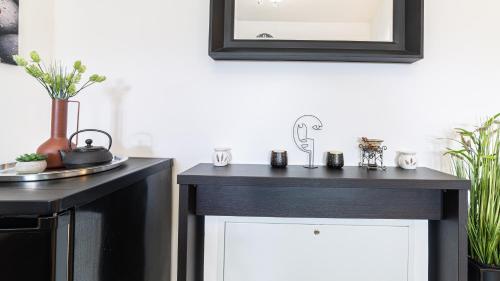 a bathroom with two black and white cabinets and a mirror at Harmony Apartment in Silver Mountain in Poiana Brasov