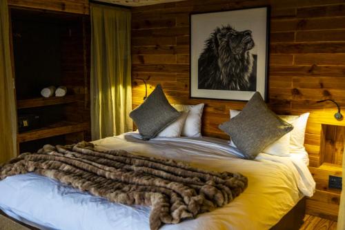a bedroom with a large bed with a leopard blanket at TimBila Safari Lodge in Omaruru