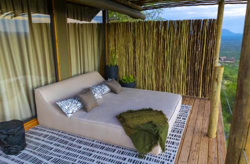 a white couch on a porch with a view at TimBila Safari Lodge in Omaruru