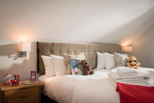 two teddy bears sitting on top of a bed at Puffin Hot tub Lodge, 4 bedrooms Resort, Pool,Gym,Bar in Padstow