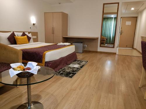 a hotel room with a bed and a glass table at IRA By Orchid Bhubaneswar in Bhubaneshwar