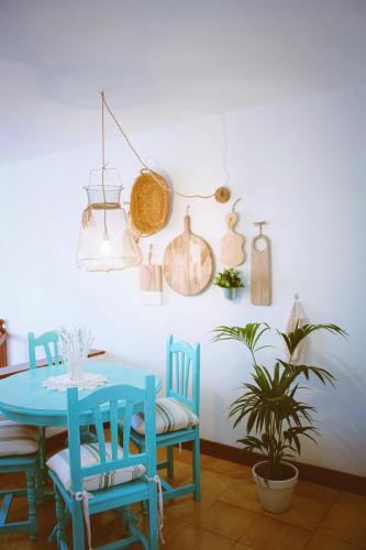 a dining room with a blue table and chairs and a plant at Casa Eneida frente al mar in Tías